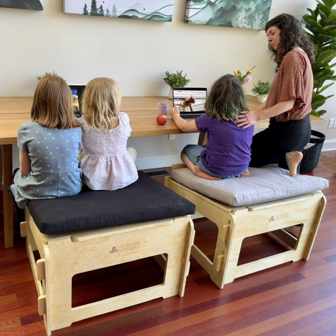 Children doing schoolwork on higher ground chairs