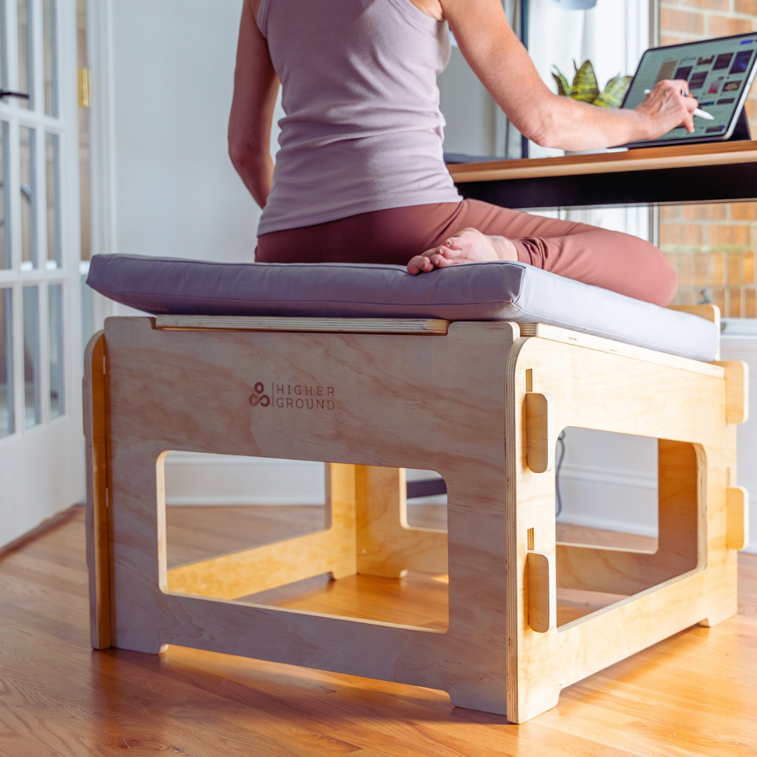 A woman sitting Japanese style (seiza) at a desk using a stylus on a tablet computer